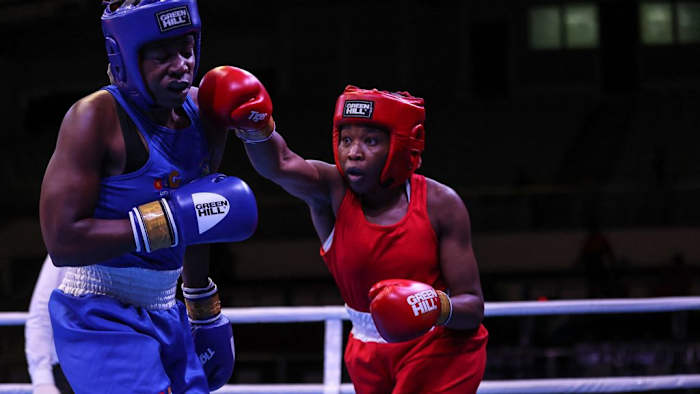 Nigeria's Patricia Mbata (R) attacks South Africa's Mkateko (L), during their elite women's 70-75kg middle bout, at the African Boxing Championships in Yaounde in August 2023. Mbata, a British born boxer of Nigerian descent was invited by the Nigerian Boxing Federation to fight for the national team. DANIEL BELOUMOU OLOMO/AFP VIA GETTY IMAGES.